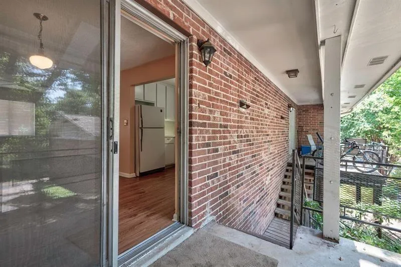View of exterior back entry featuring brick siding.