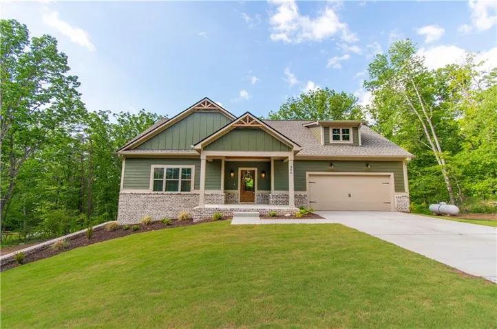 Craftsman-style exterior with board-and-batten siding, stone accents, a covered entry, and an attached garage