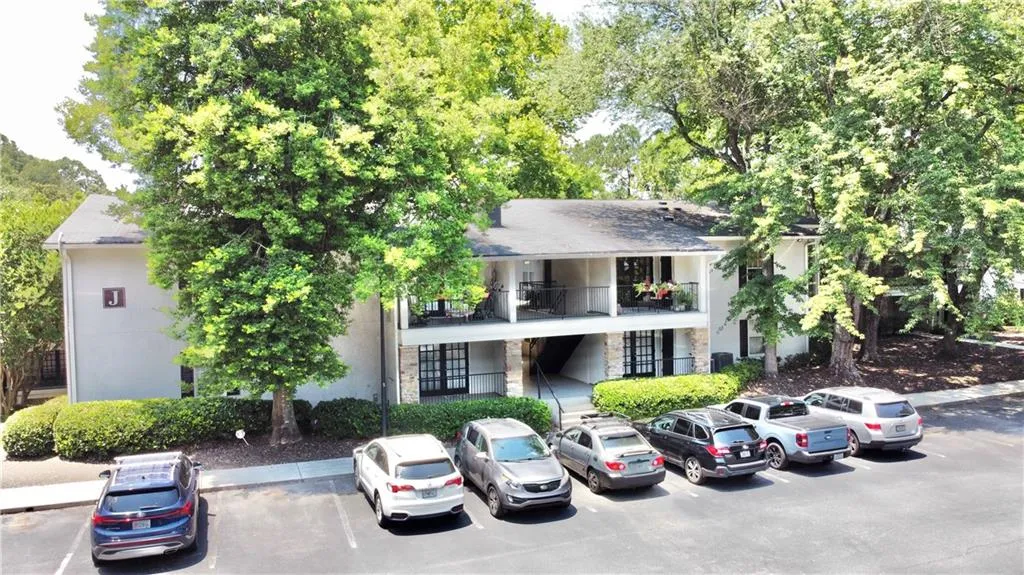 View of building exterior featuring uncovered parking