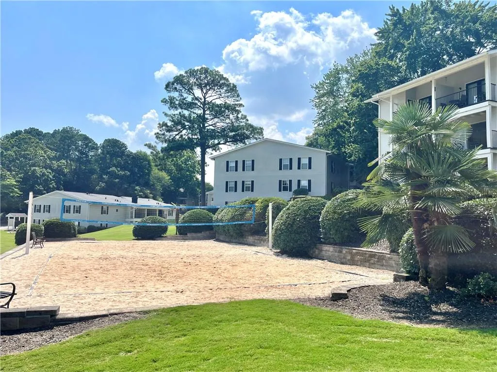 View of property's community featuring volleyball court and a lawn