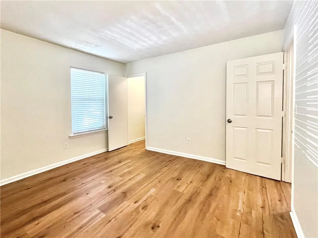 Unfurnished bedroom with light wood finished floors and a textured ceiling