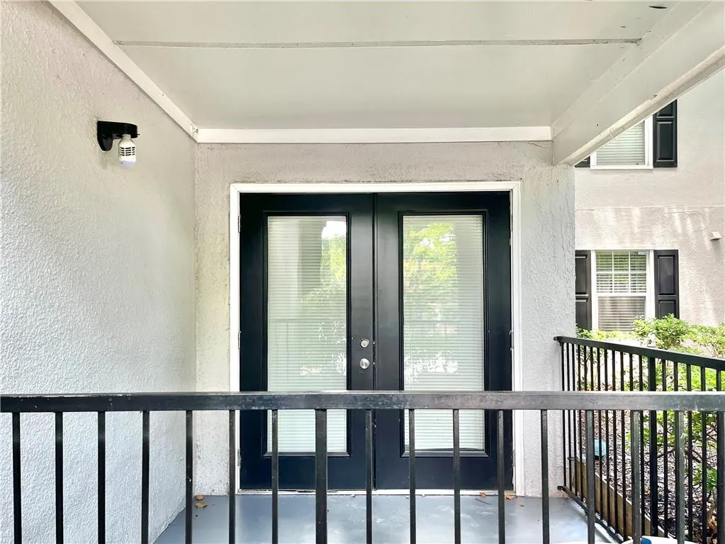 Doorway to property featuring french doors and stucco siding