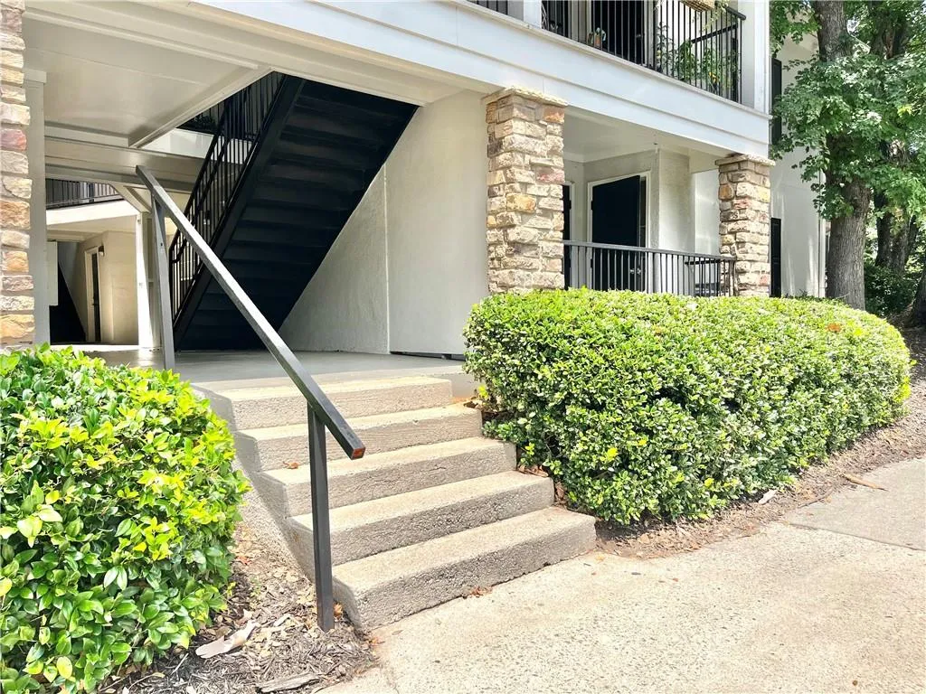Doorway to property with stone siding and stucco siding