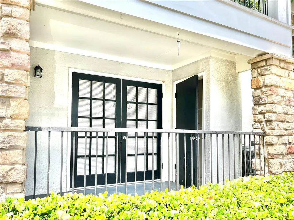 Entrance to property with french doors, stucco siding, and stone siding