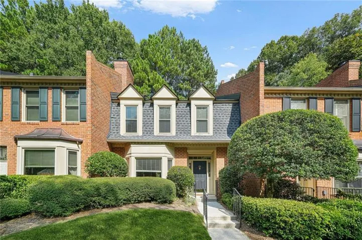 Brick exterior with black shutters and a prominent bay window