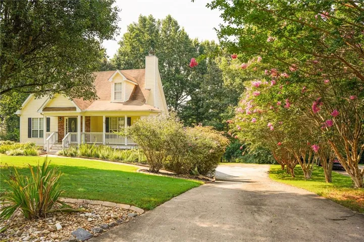 Traditional-style residence with a covered front porch featuring white railings