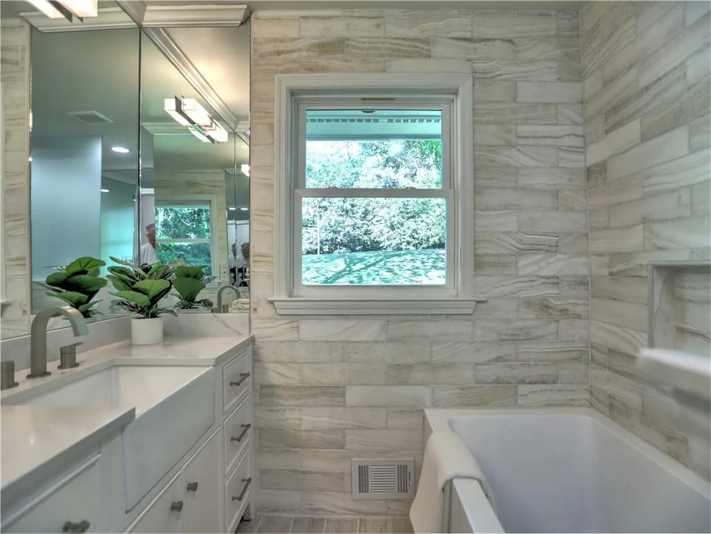 Bathroom featuring vanity and tile walls