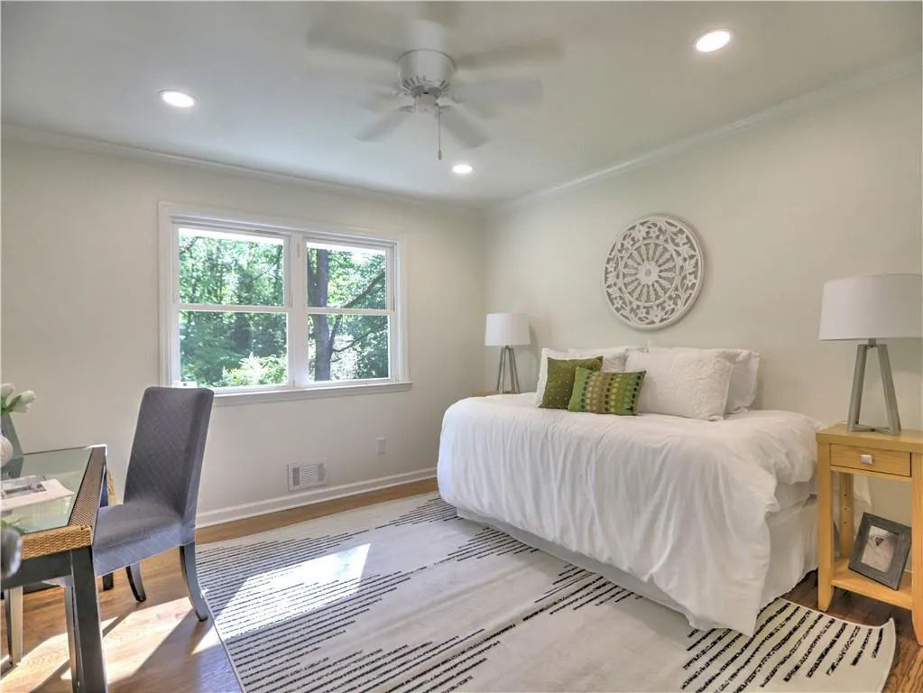 Bedroom with ornamental molding, ceiling fan, and hardwood / wood-style flooring