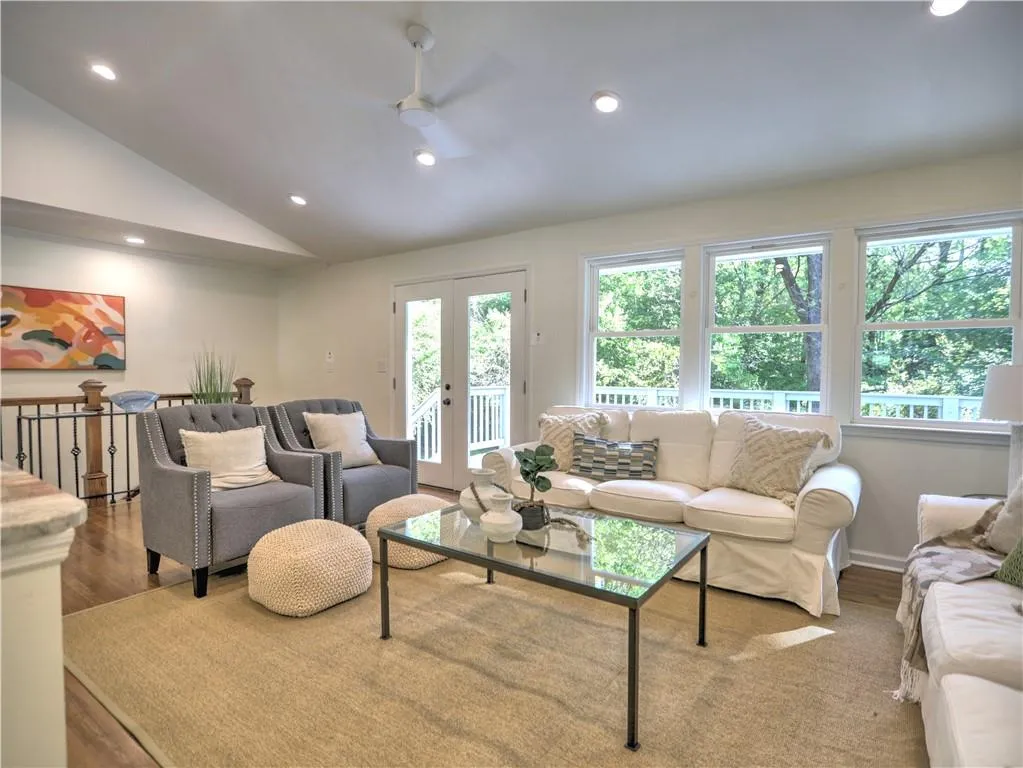 Living room featuring hardwood / wood-style floors, vaulted ceiling, and a healthy amount of sunlight