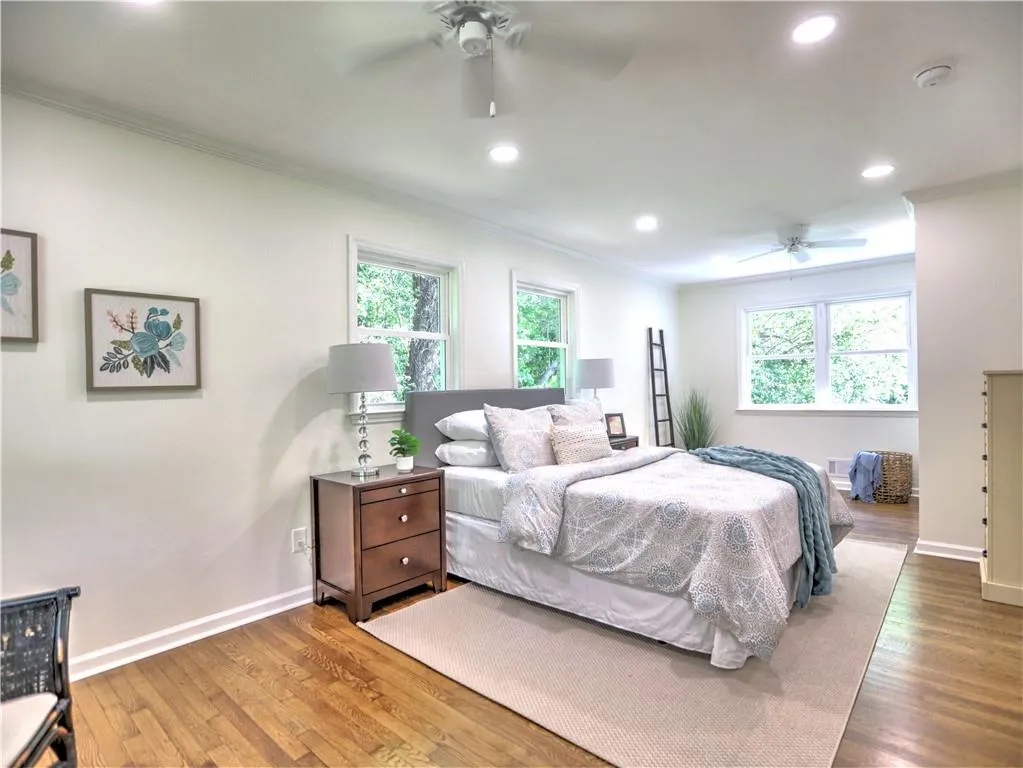 Bedroom featuring crown molding, dark wood-type flooring, and ceiling fan