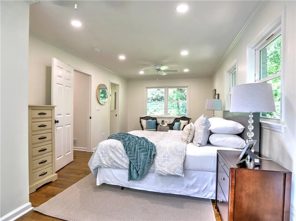 Bedroom with crown molding, wood-type flooring, and ceiling fan