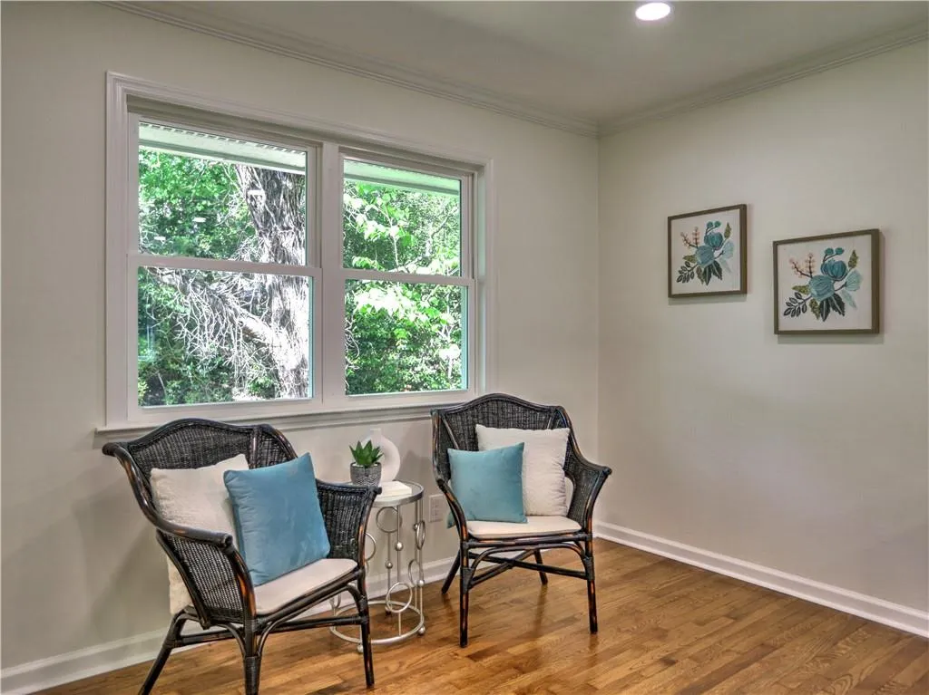 Living area featuring ornamental molding and hardwood / wood-style flooring