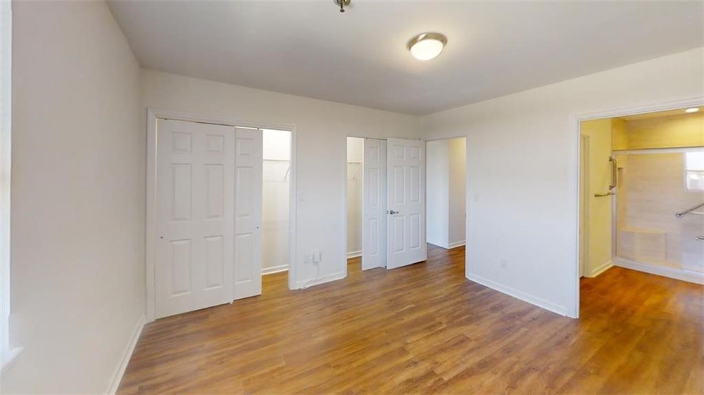 Unfurnished bedroom featuring dark hardwood / wood-style floors