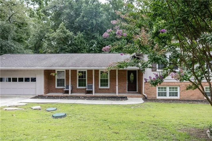 Brick residence featuring an attached garage with a panel door