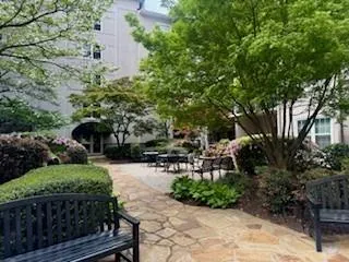 View of home's community courtyard with water fountain and outdoor grill.