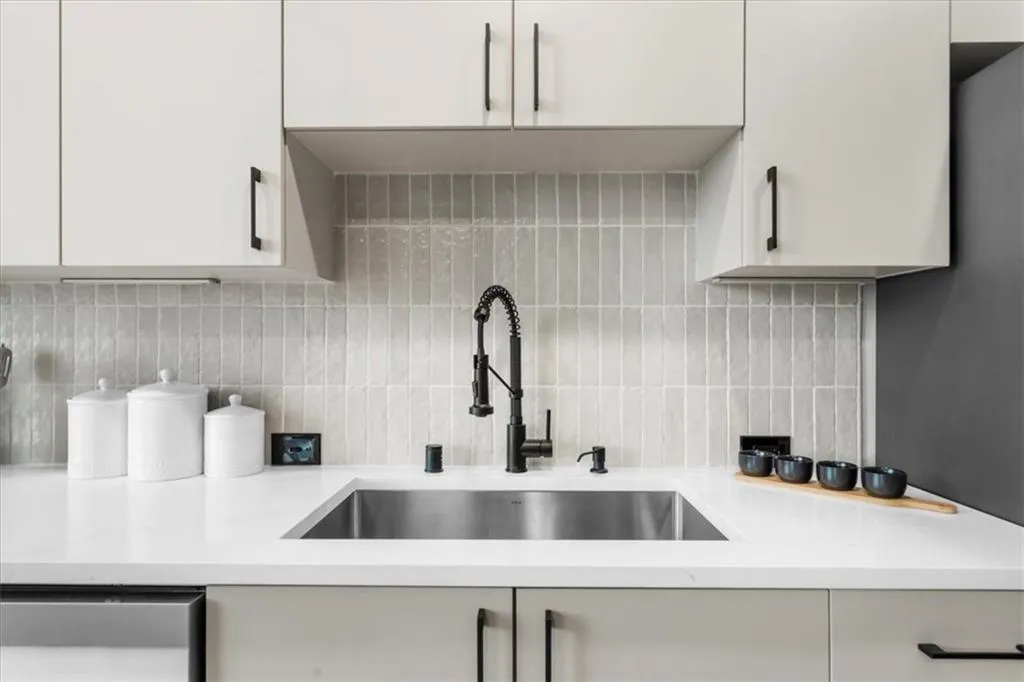 Kitchen with Edward Martin tile backsplash and light stone counters