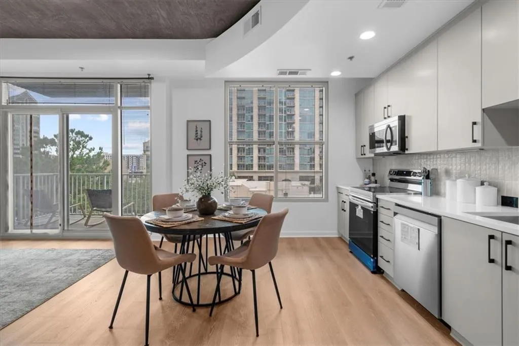 Kitchen with stainless steel appliances, light wood-style floors, Edward Martin tile backsplash, modern cabinets, new lighting & fixtures