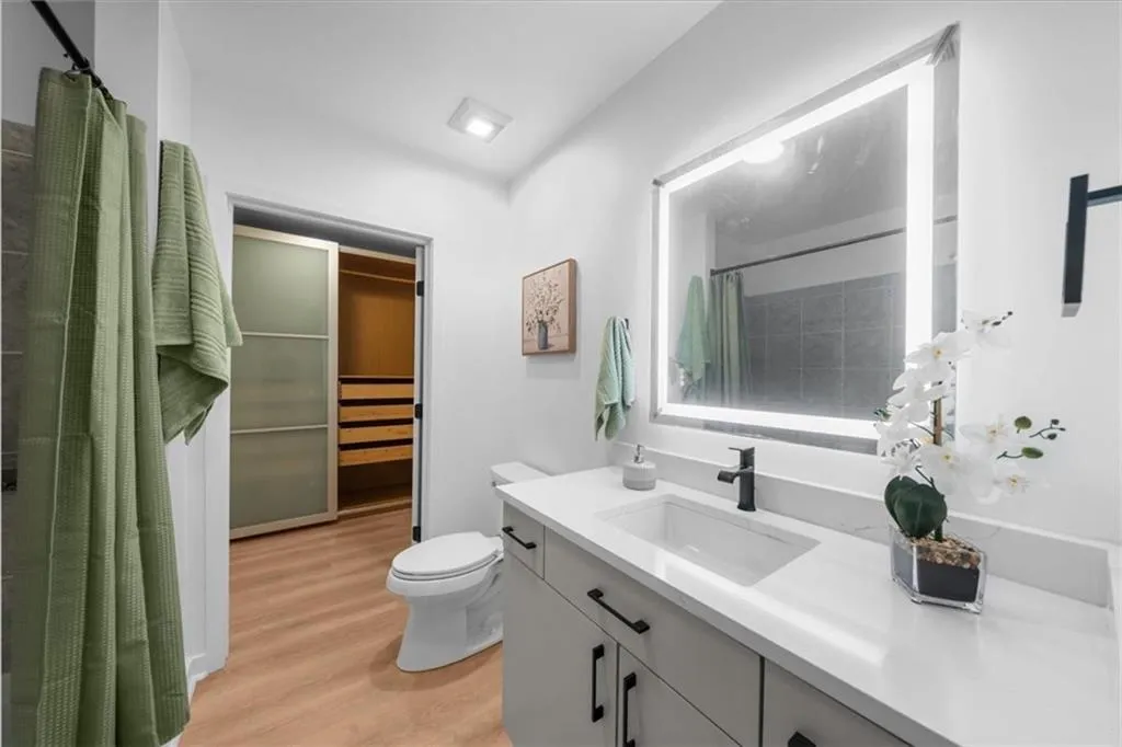 Full bathroom with large soaking tub, shower, new vanity, new smart mirror, new lighting, new wide plank light oak flooring and a super quiet new whispering fan!