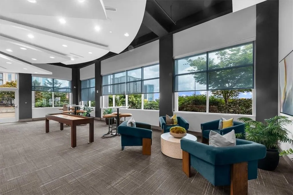 Common area featuring recessed with views to pool and access to outdoor grill area