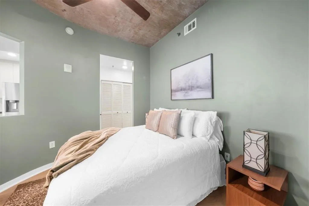 Bedroom with new ceiling fan & new wide plank light wood flooring