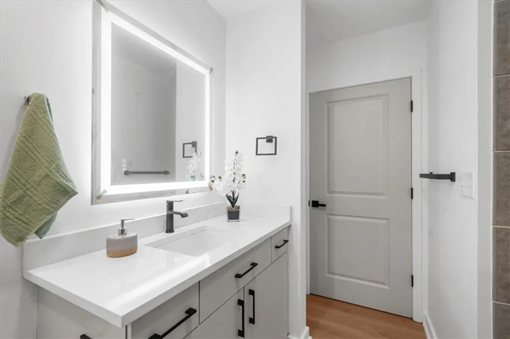 Full bathroom with large soaking tub, shower, new vanity, new smart mirror, new lighting, new wide plank light oak flooring and a super quiet new whispering fan.
