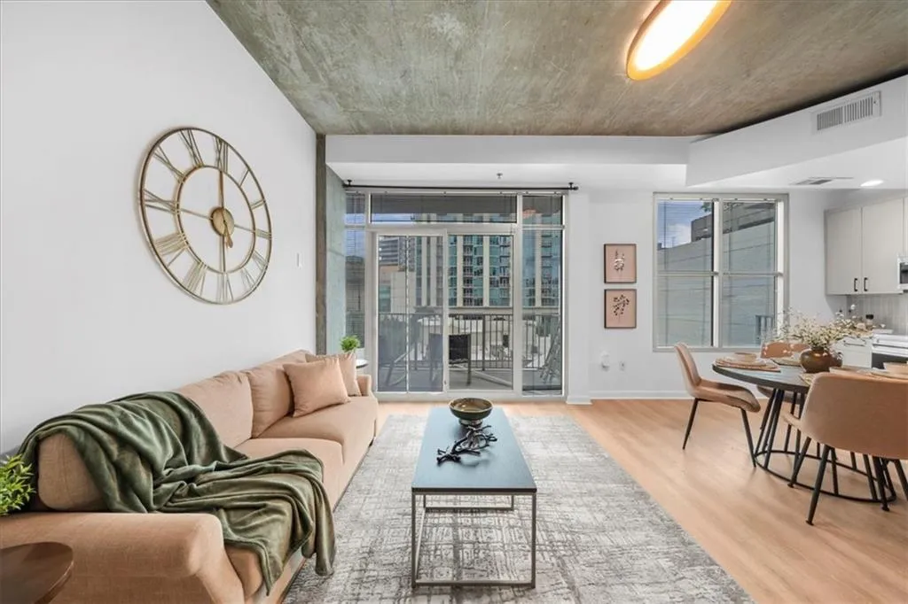 Living room with plenty of natural light, light wood-style flooring, and expansive windows