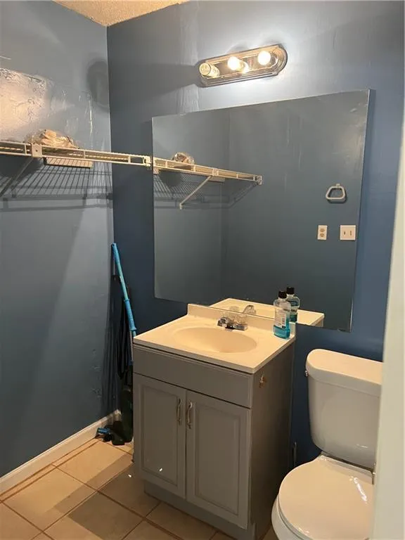 Bathroom featuring toilet, tile floors, and oversized vanity