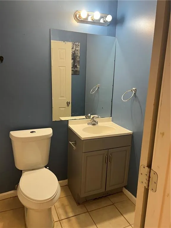 Bathroom with toilet, tile flooring, and vanity