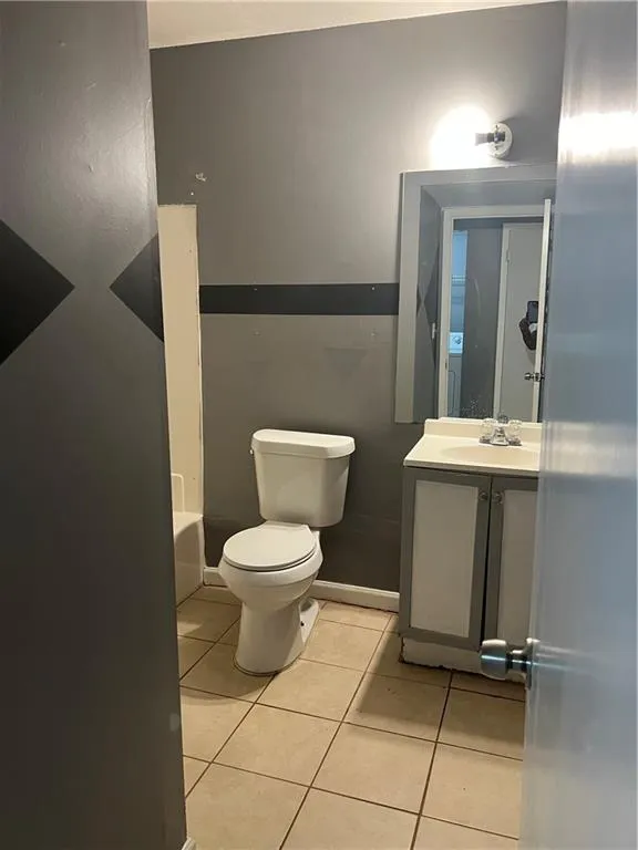 Full bathroom with vanity, toilet, tile floors, and shower / tub combination