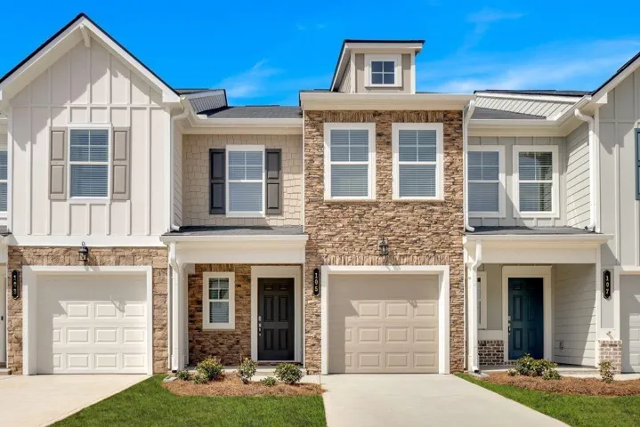 Craftsman inspired home with board and batten siding, stone siding, concrete driveway, covered porch, and a garage