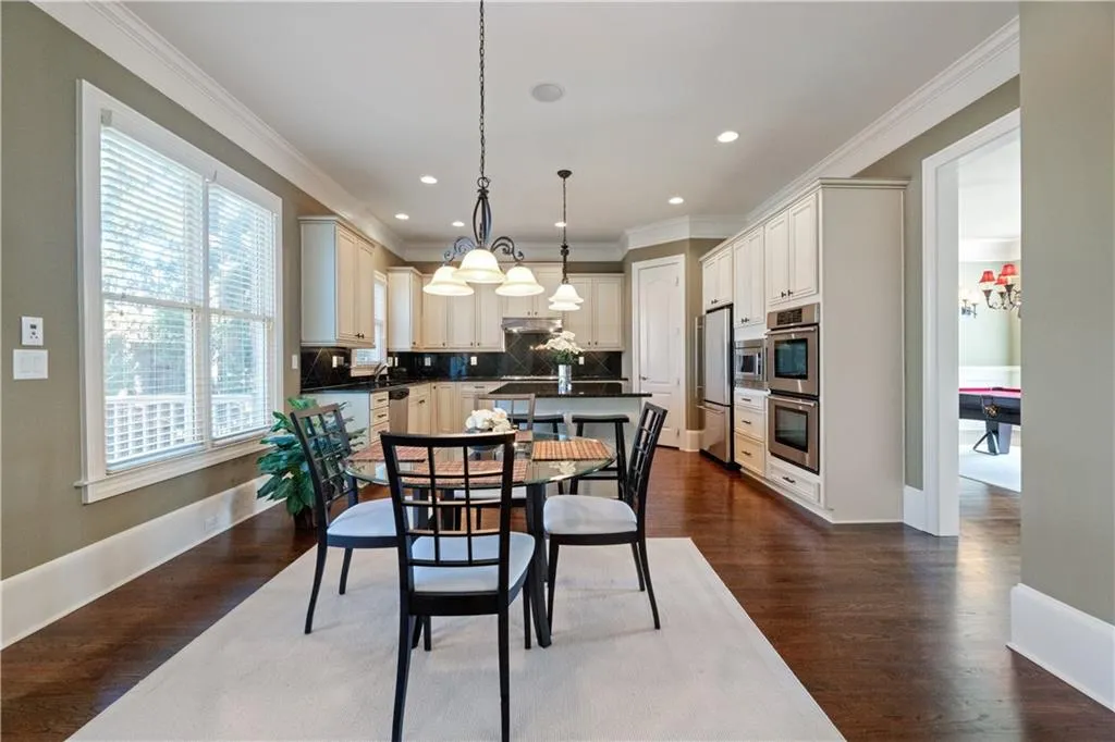 Dining area with dark wood-style floors, baseboards, ornamental molding, and recessed lighting