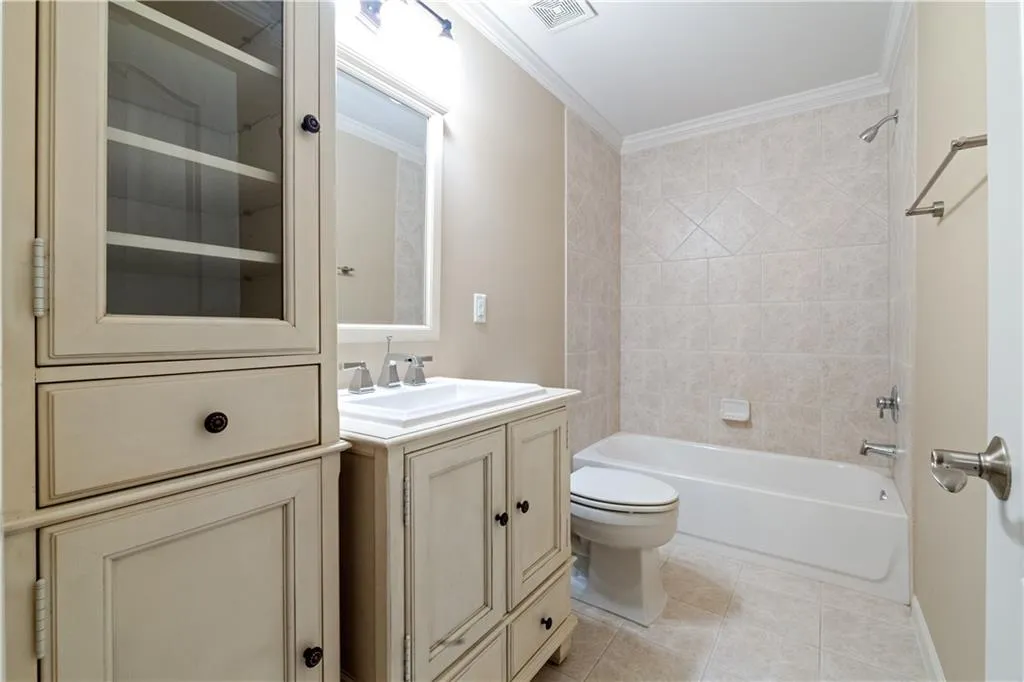 Bathroom with visible vents, toilet, ornamental molding, vanity, and tile patterned flooring