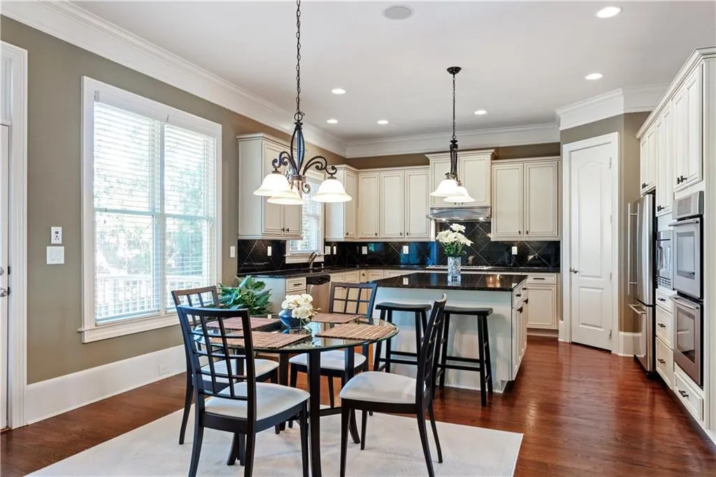 Kitchen with ornamental molding, dark countertops, a center island, and dark wood-style flooring