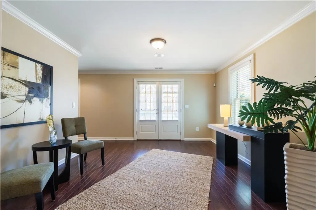 Entrance foyer with baseboards, ornamental molding, dark wood-type flooring, and french doors
