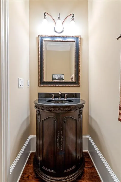 Bathroom featuring wood finished floors, vanity, and baseboards