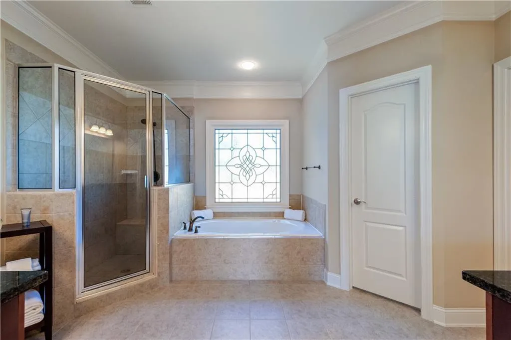 Full bath featuring ornamental molding, a stall shower, tile patterned flooring, and a garden tub
