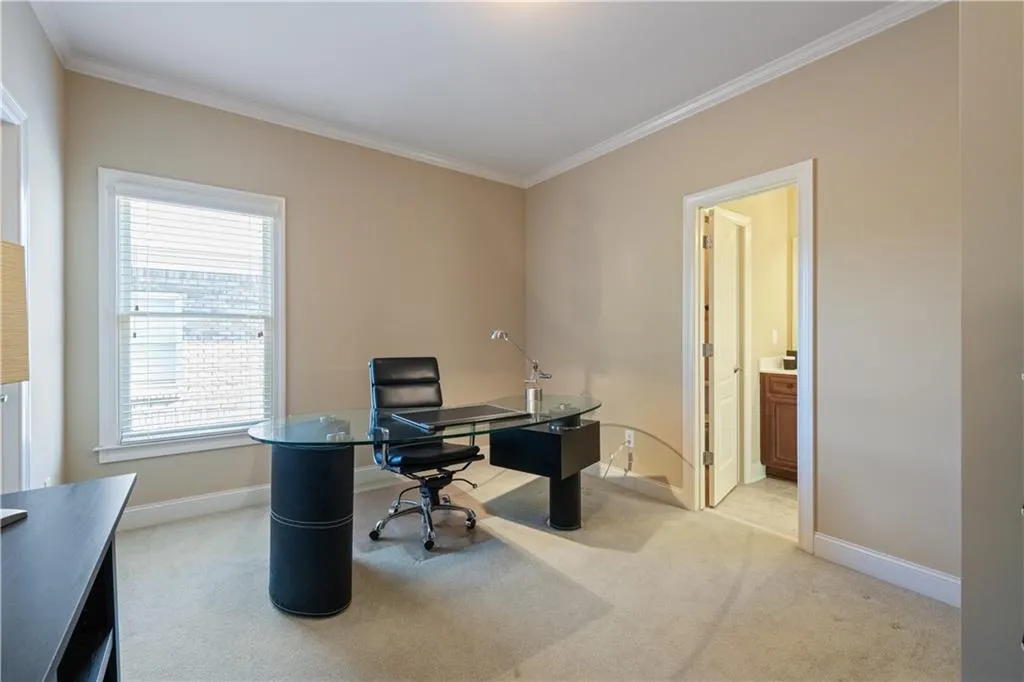 Office area with baseboards, ornamental molding, and light colored carpet