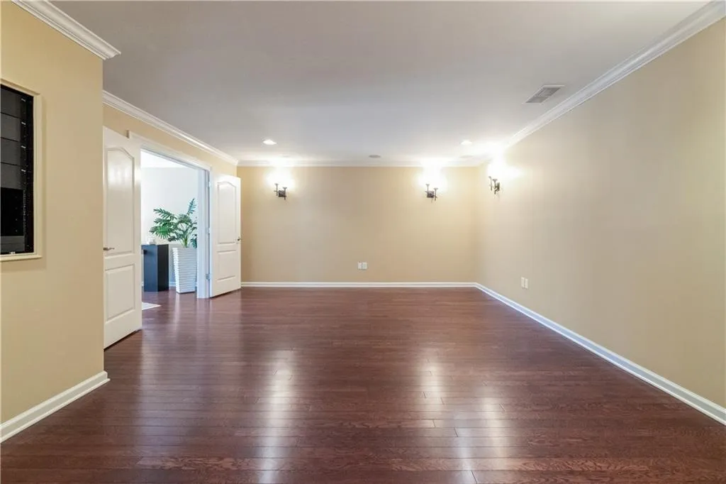 Unfurnished room with hardwood / wood-style flooring, baseboards, and visible vents