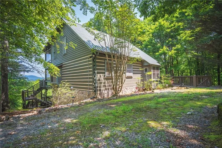 Rustic-style home featuring log-siding construction and a durable metal roof