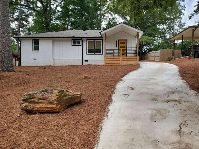 Contemporary white exterior with board and batten and horizontal siding, black-framed windows, a welcoming covered porch with a wood railing, and a vibrant yellow entry door