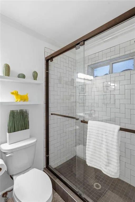 Walk-in shower with clear glass sliding door. Custom tile