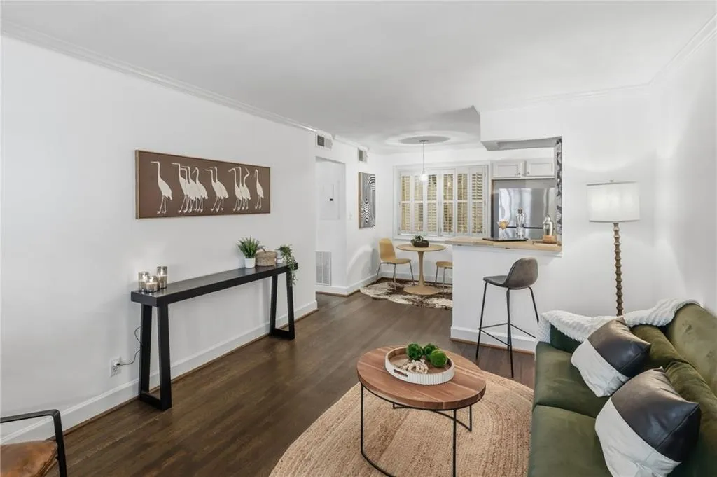 Open-concept living space featuring hard wood floors,  and a pass-through kitchen with a breakfast bar.