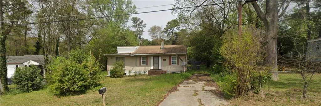Single-story residence with a front porch, a chimney, and a front yard with mature trees