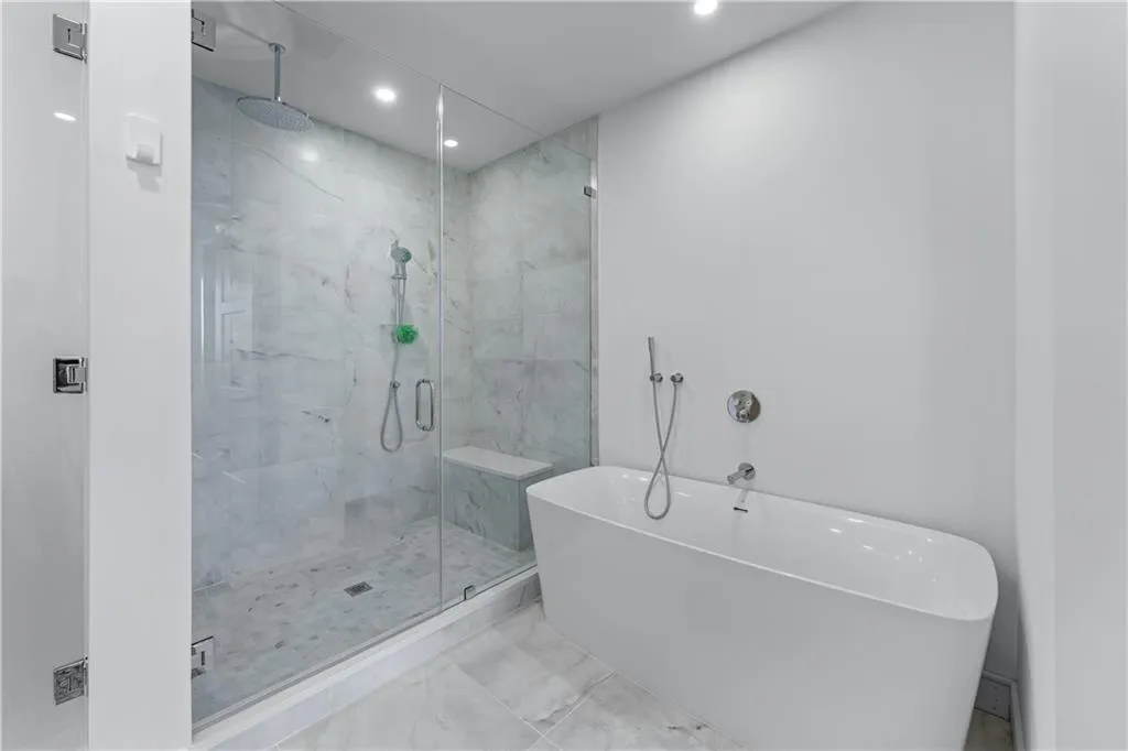 Full bath featuring recessed lighting, a freestanding tub, a marble finish shower, and marble finish flooring