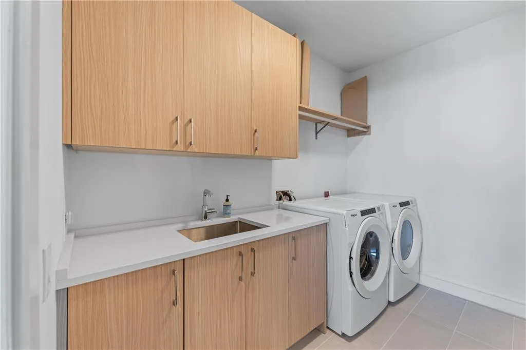 Laundry area featuring cabinet space, washing machine and clothes dryer, and light tile patterned floors