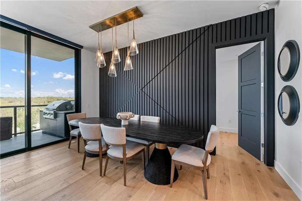 Dining area with a wall of windows, a chandelier, and light wood-style floors