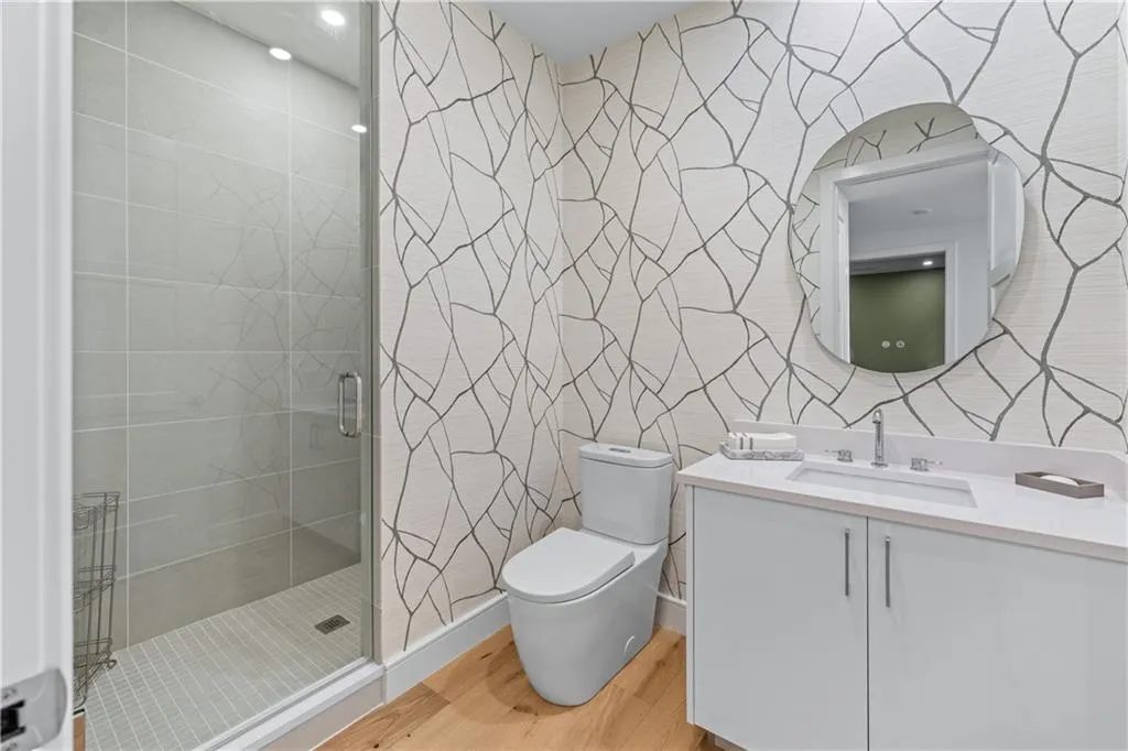 Bathroom featuring wood finished floors, vanity, and a stall shower
