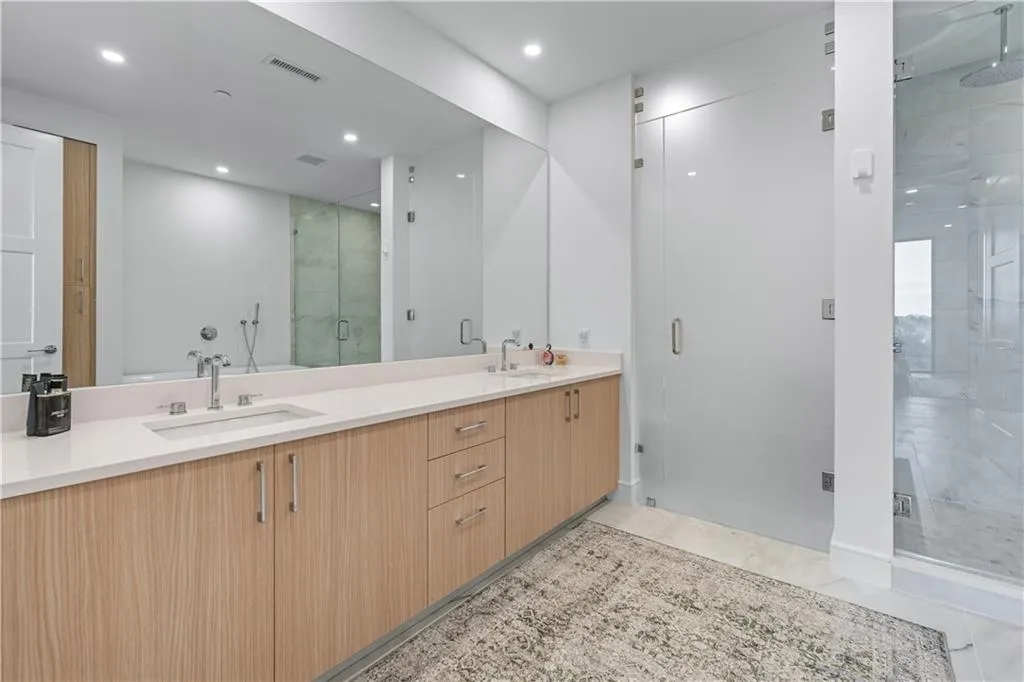 Full bath with a shower stall, double vanity, and recessed lighting