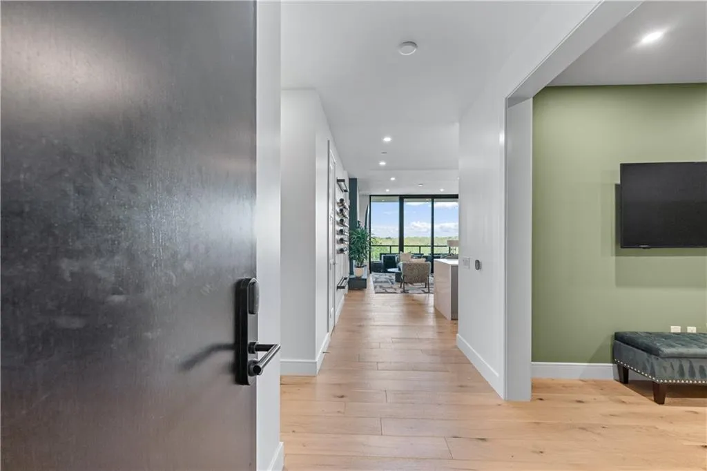 Hall with light wood-style flooring, recessed lighting, and a wall of windows