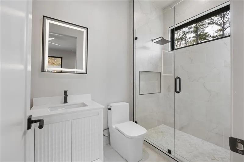 Full bath with a marble finish shower and vanity